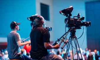 Broadcast camera crew filming a live covered event