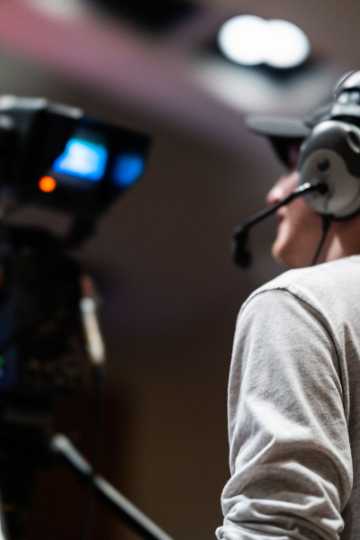 Cameraman operating a broadcast camera with headset on a shoot