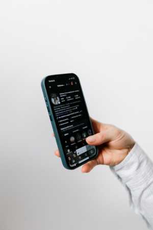 Hand holding a smartphone displaying a social media app